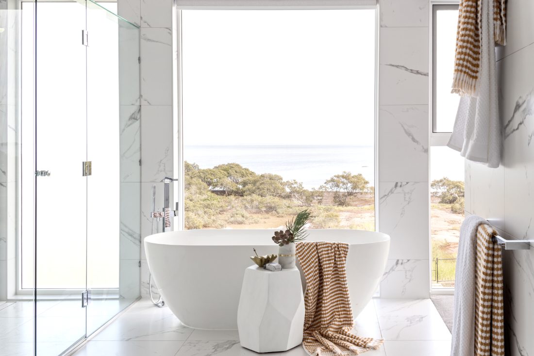 Freestanding bath with floor-mounted mixer in a coastal ensuite