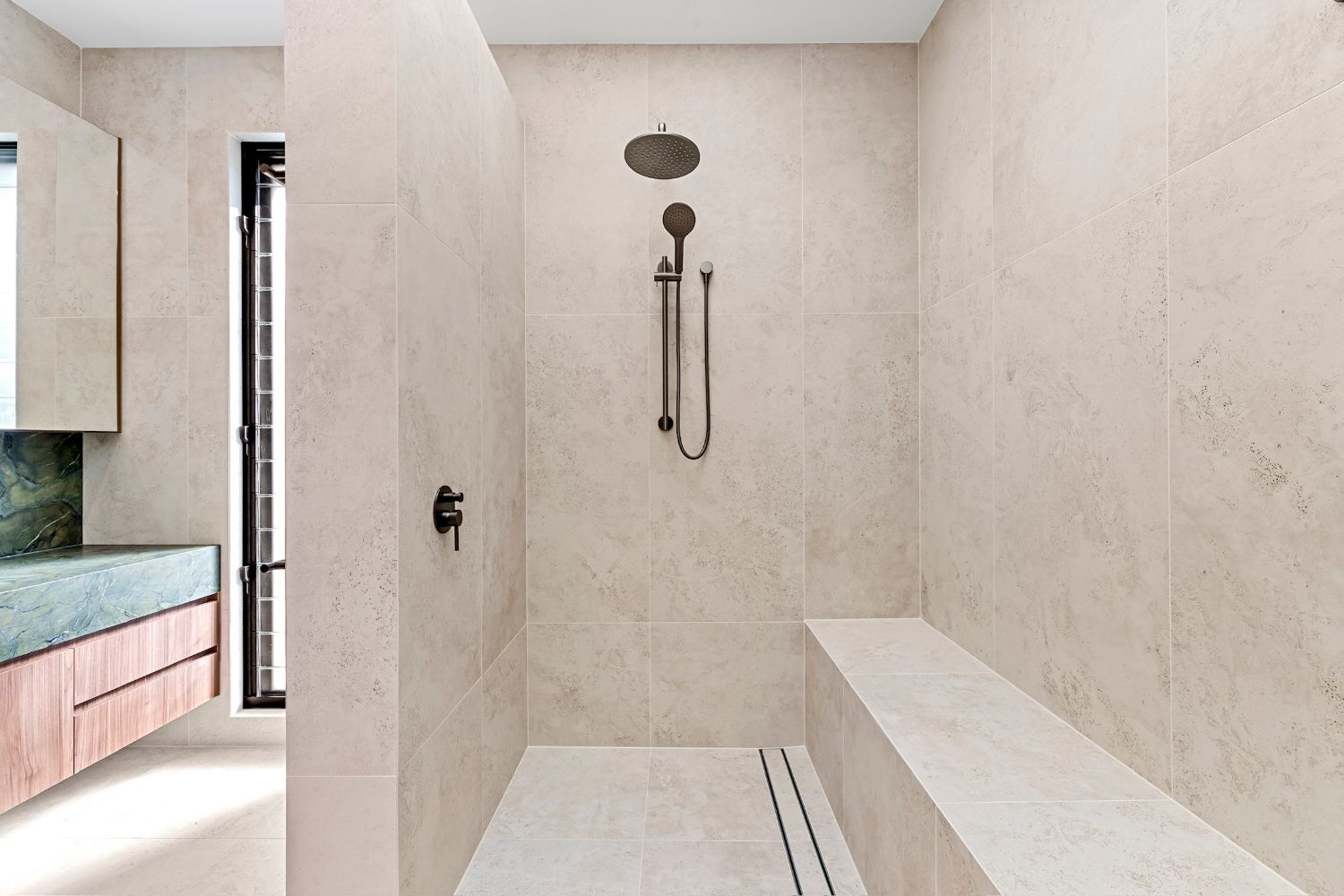 Walk-in shower with tiled bench seat and linear floor waste